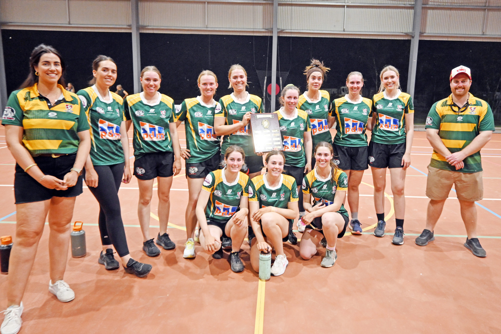 The Country netball team celebrate their 29-22 win over Town with Julia Creek Combined Sporting Association secretary Martha Hurst (left) and president Kalan Lococo (right).