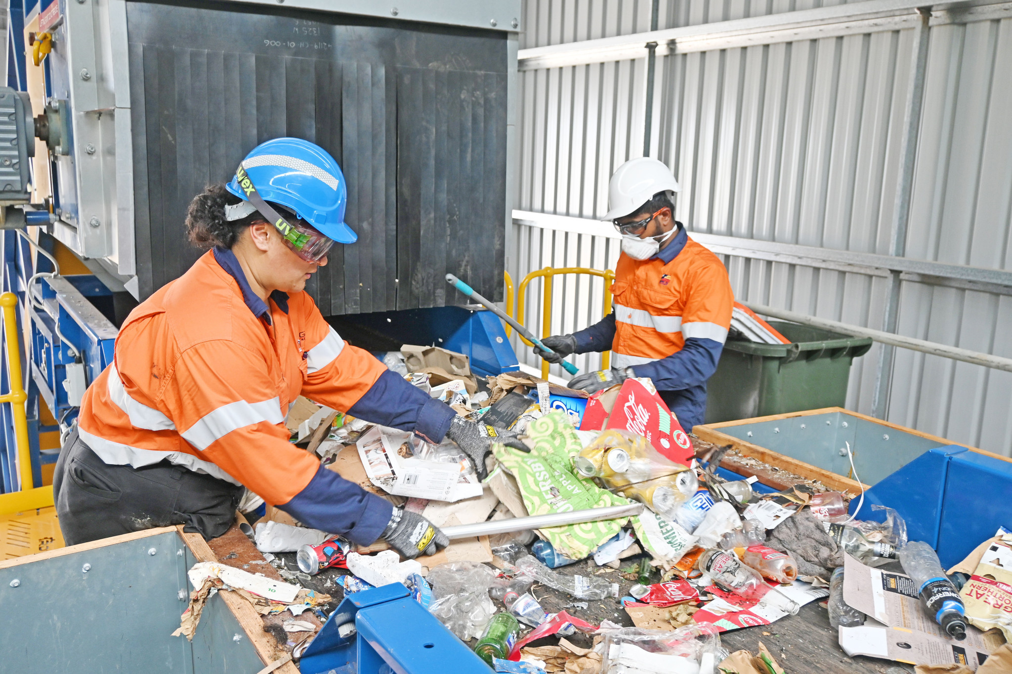 Two workers rummage at the pre-sorting point in search of hazardous materials.