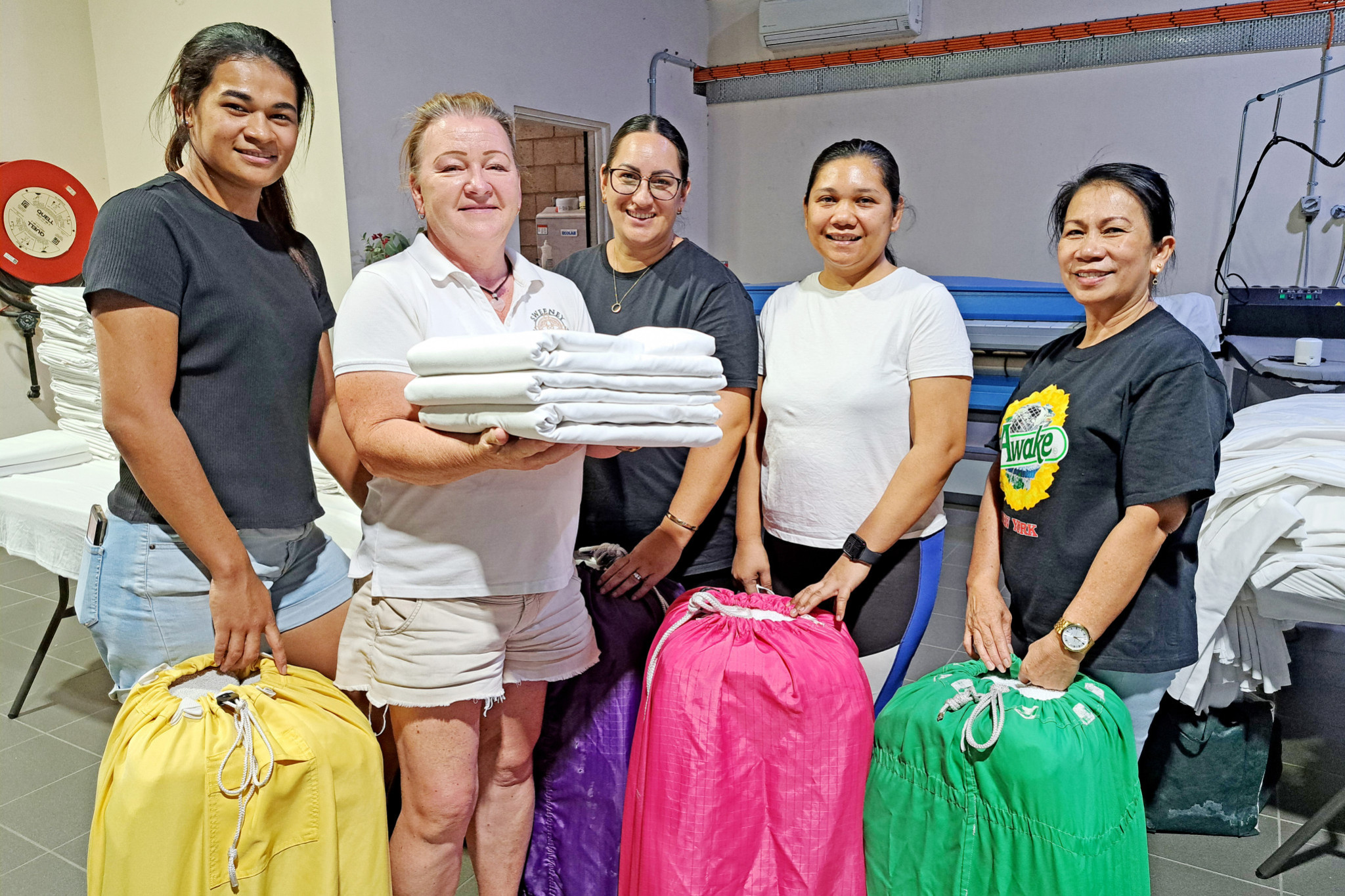 Sweeney Contracting Services owner Verity Sweeney (second from left) with some of her staff members in the Miles Street commercial laundry that she started from scratch after working her way up from a domestic house cleaner.