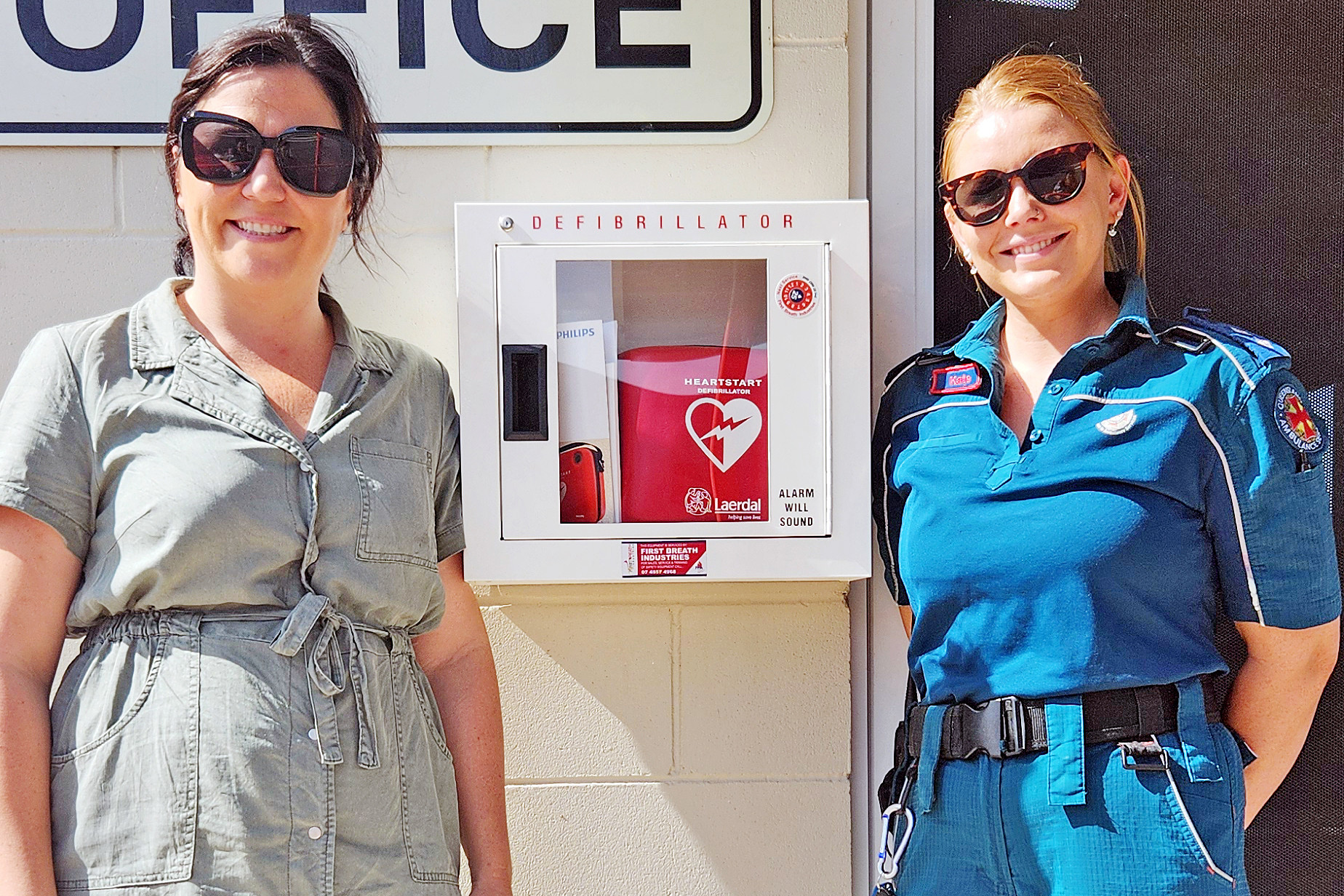 Flinders Shire mayor Kate Peddle and Hughenden QAS office-in-charge Kate Verkroost with the new automated external defibrillator (AED) at the Allen Terry Caravan Park in Hughenden.