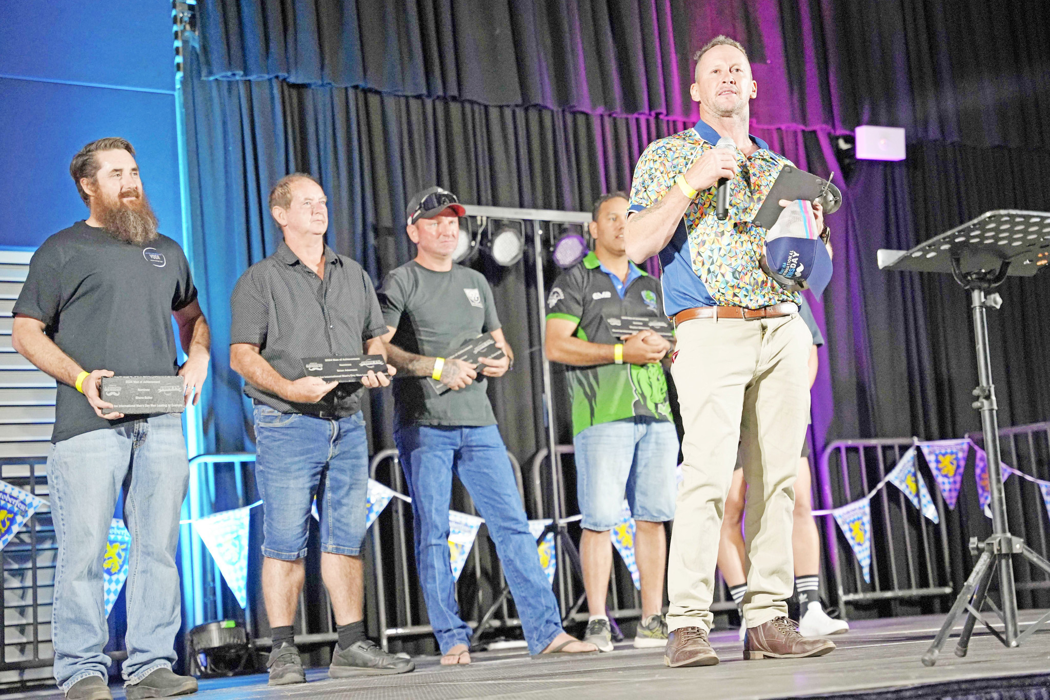 Darryl Avery, right, accepts the Man of Achievement Award at the Buchanan Park events centre on Saturday night. Behind him on the stage are finalists Shane Butler, Brian Adamson, Malcolm Willis and Rhyston Williamson.