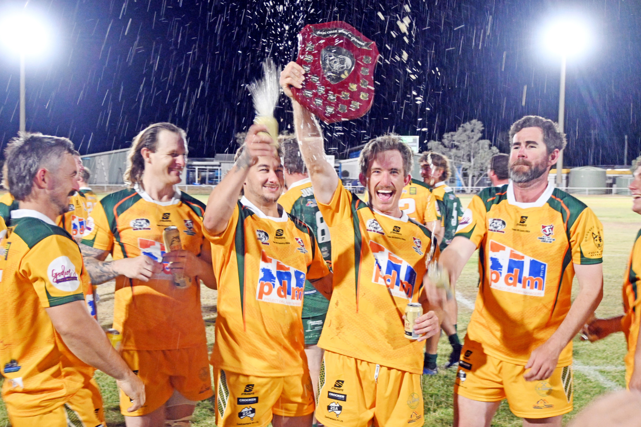 Town rugby league captain Calem Fegan holds the shield aloft.