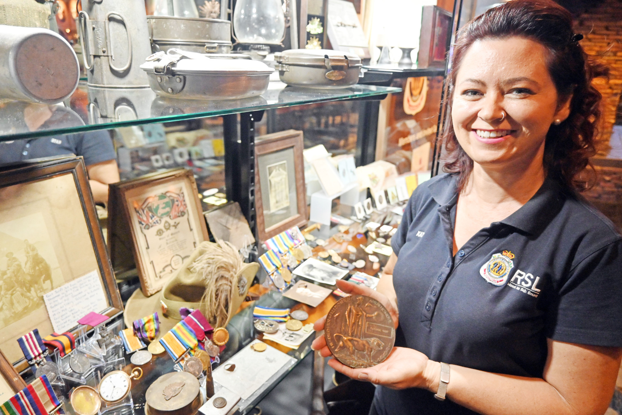 Mount Isa RSL Sub Branch treasurer Kate Fischer looks over some of the items in the new display cabinet.