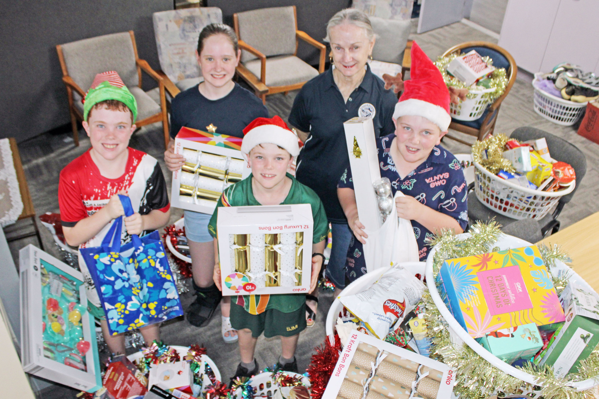 Preparing the gifts were St Vincent De Paul long term volunteer Kendall Santillan and Georgia Carland with Parker, Finlay and Fletcher Sheehan.