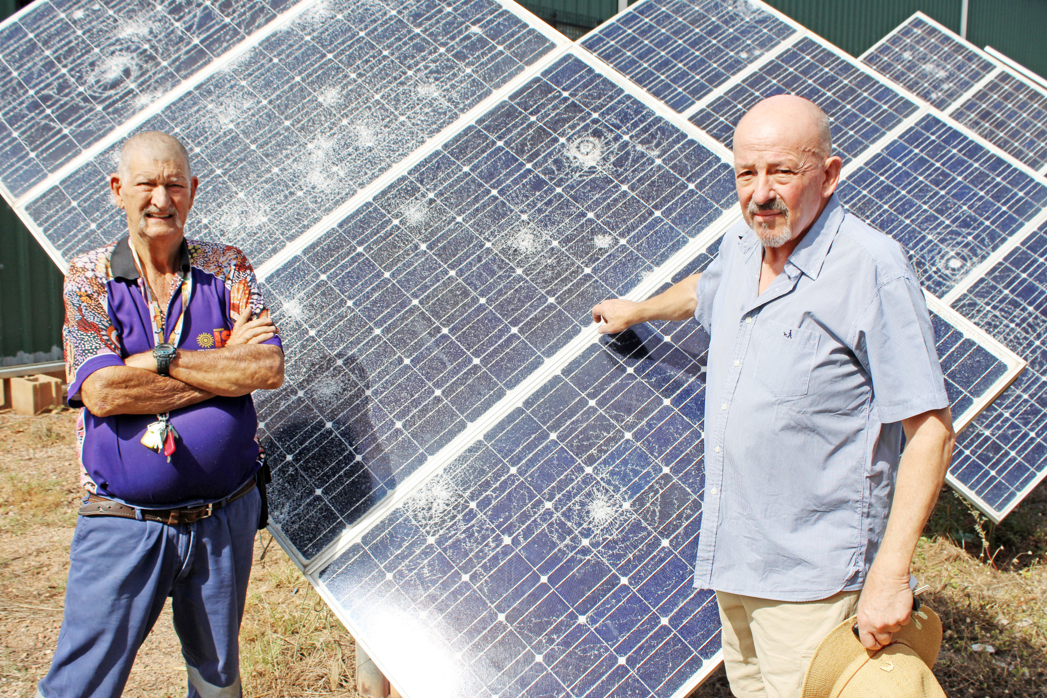 Outback at Isa employee Alan Rackham and centre manager Martin Turner with some of the large solar panels that were destroyed by several youths earlier this month.